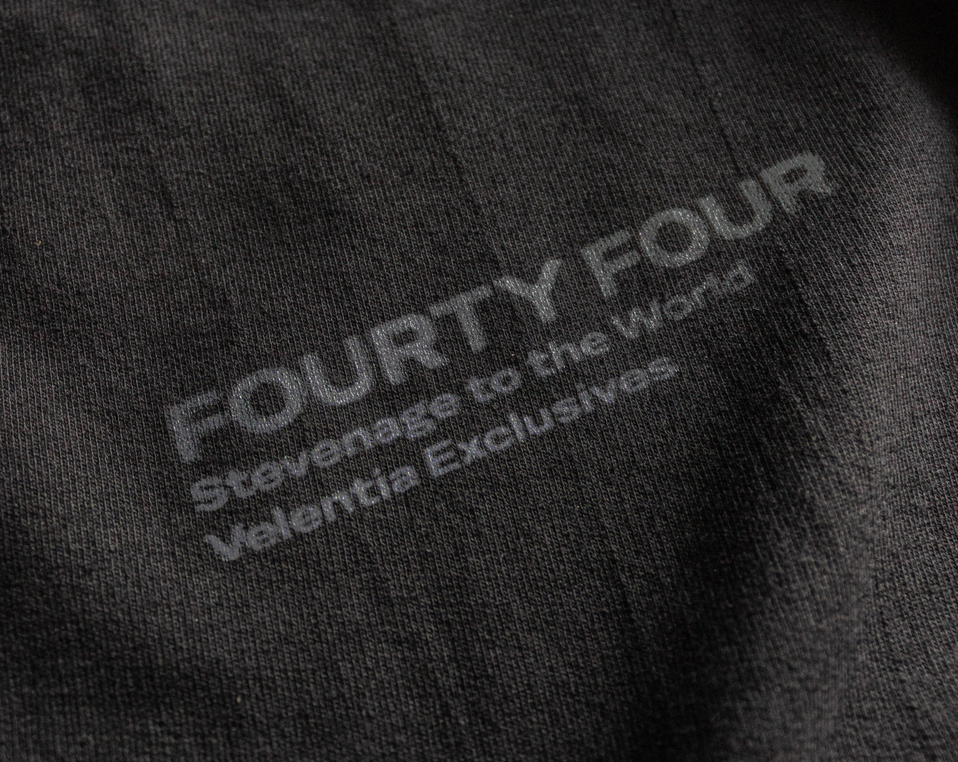 Close-up of Velentia black Tokyo T-shirt showing detailed motorsport inspired text graphic screen print